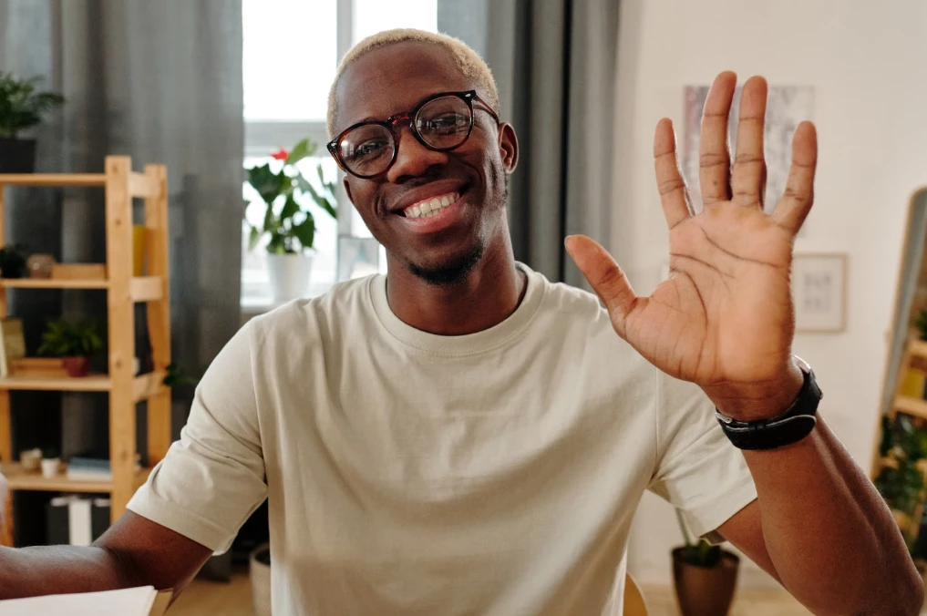 Patient smiling and waving hello on a video visit